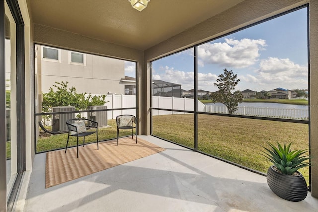 sunroom featuring a water view