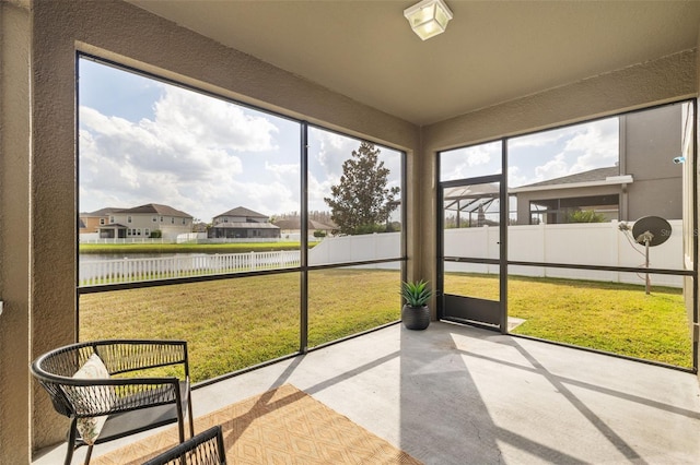 sunroom / solarium featuring a water view