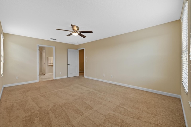 unfurnished bedroom featuring connected bathroom, light colored carpet, and ceiling fan