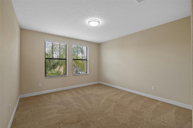 carpeted empty room with a textured ceiling