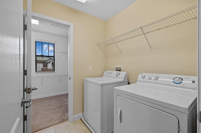 washroom with washer and clothes dryer, light colored carpet, and a textured ceiling