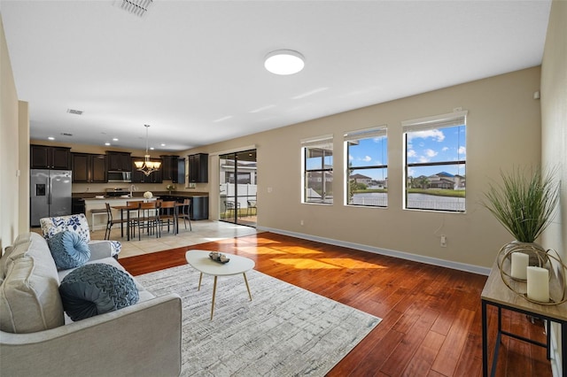 19429 Paddock View Dr, Tampa, FL 33647 - living room featuring plenty of natural light, light wood-style flooring, baseboards, a chandelier, and recessed lighting