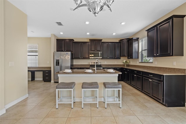 19429 Paddock View Dr, Tampa, FL 33647 - kitchen with appliances with stainless steel finishes, plenty of natural light, a center island with sink, dark stone countertops, and recessed lighting