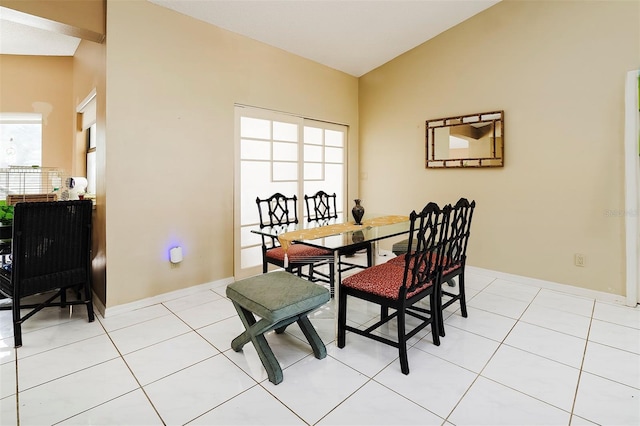 tiled dining room with lofted ceiling