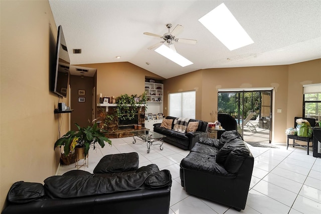 living room featuring lofted ceiling with skylight, light tile patterned floors, and a textured ceiling