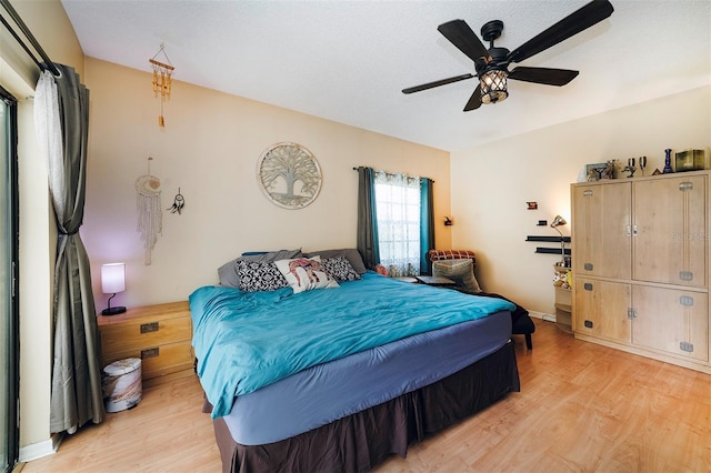 bedroom featuring lofted ceiling, ceiling fan, and light wood-type flooring