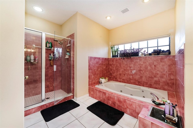 bathroom with tile patterned floors and shower with separate bathtub