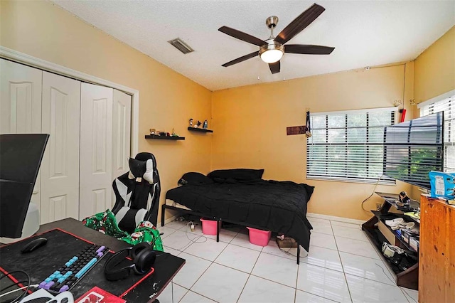 tiled bedroom featuring ceiling fan and a closet