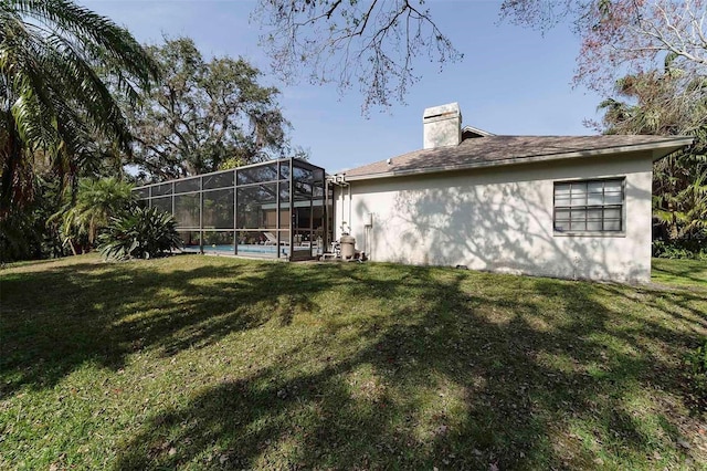 back of property featuring a yard and a lanai