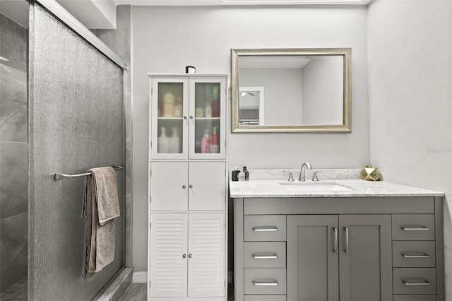 bathroom with a shower with door and vanity