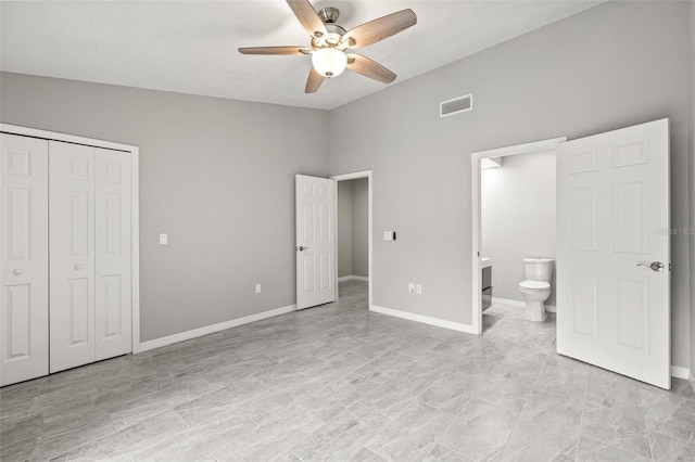 unfurnished bedroom featuring ceiling fan, ensuite bath, and a closet