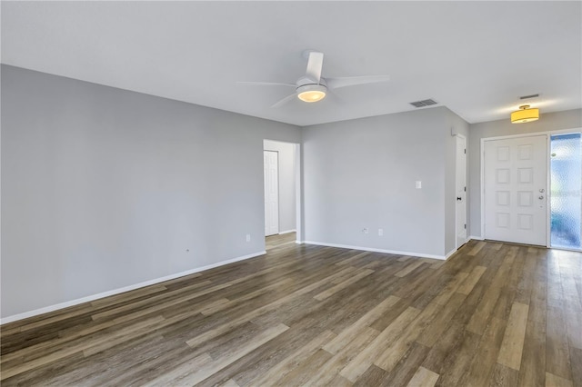 empty room with dark wood-type flooring and ceiling fan