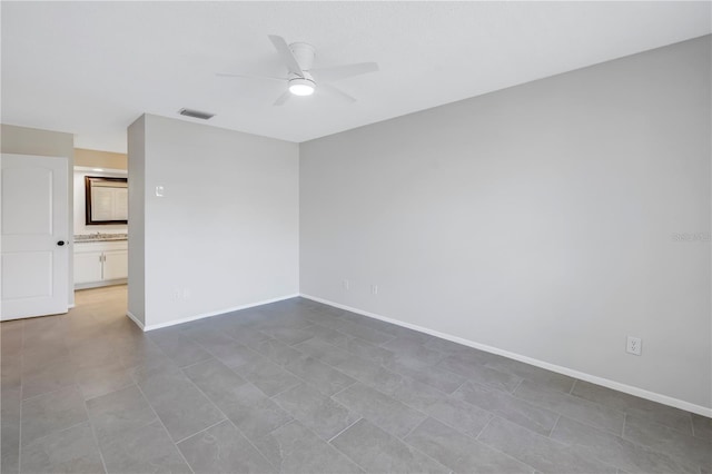 empty room featuring ceiling fan and sink