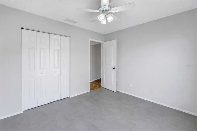 unfurnished bedroom with ceiling fan and a closet