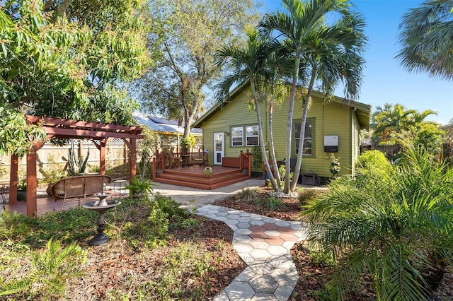 rear view of house with a pergola and a deck