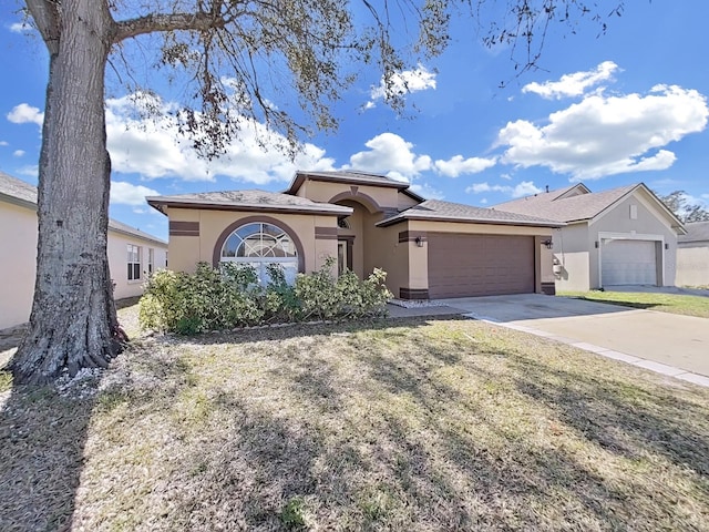 ranch-style home featuring a garage, a front lawn, concrete driveway, and stucco siding