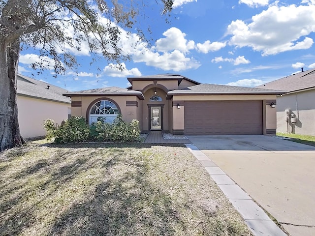 view of front of home featuring a garage, concrete driveway, and stucco siding