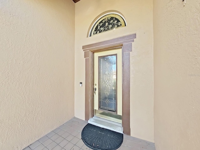 doorway to property featuring stucco siding