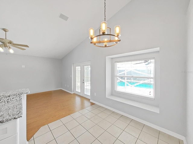 interior space featuring light wood-type flooring, plenty of natural light, ceiling fan with notable chandelier, and french doors