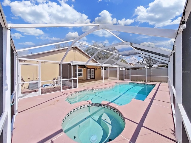 view of pool with a pool with connected hot tub, a lanai, and a patio