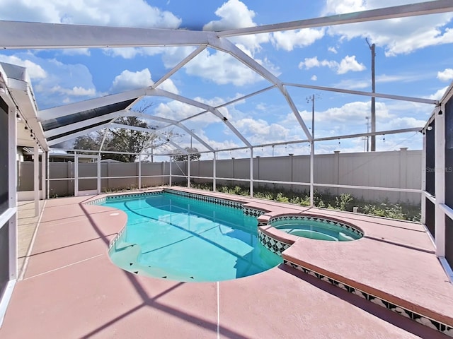 view of swimming pool with a lanai, a fenced backyard, a pool with connected hot tub, and a patio