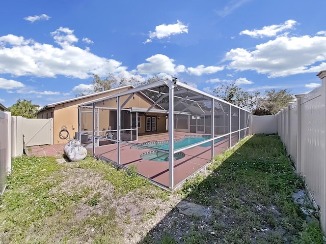 rear view of property featuring a fenced in pool, a lanai, a patio area, and a fenced backyard