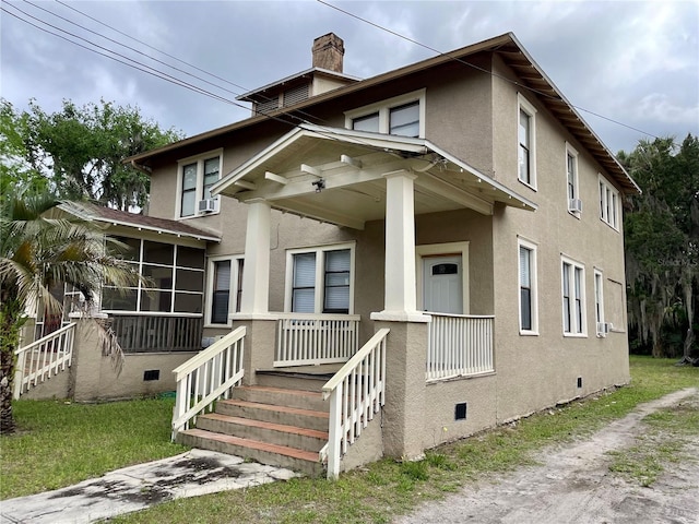 view of front of home with covered porch and a sunroom