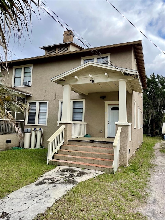 view of front of house with a porch and a front lawn