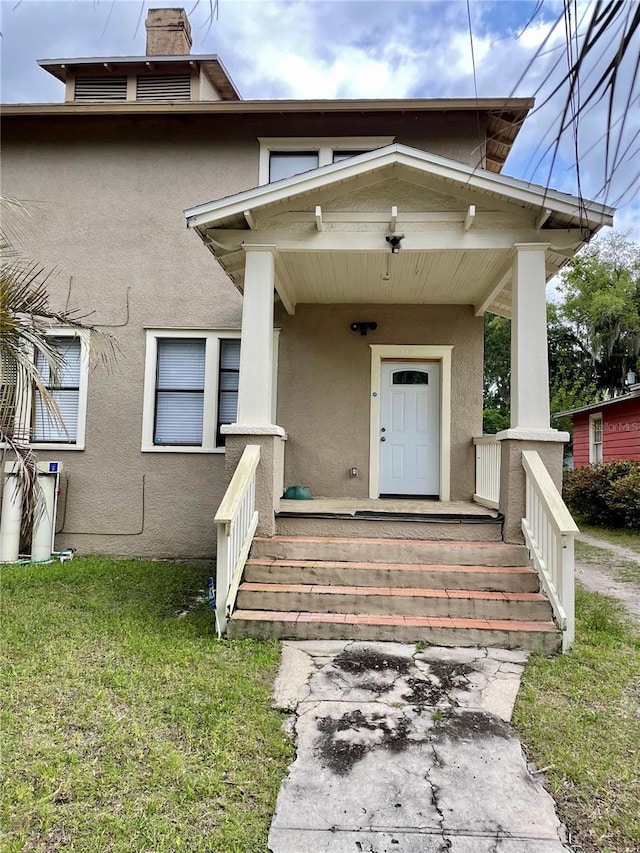 property entrance featuring a lawn