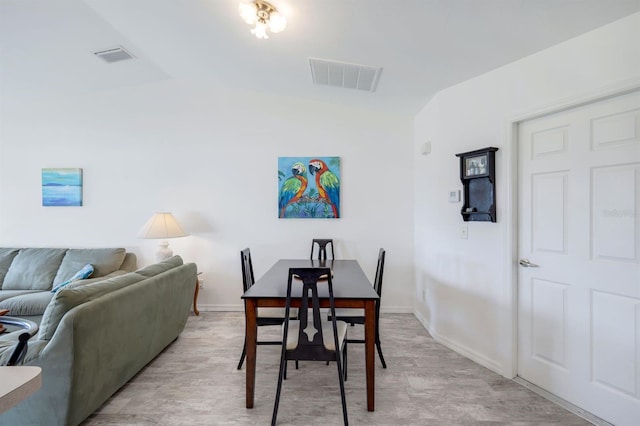 dining room featuring light hardwood / wood-style floors and vaulted ceiling