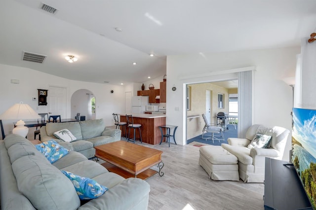 living room featuring vaulted ceiling and light wood-type flooring