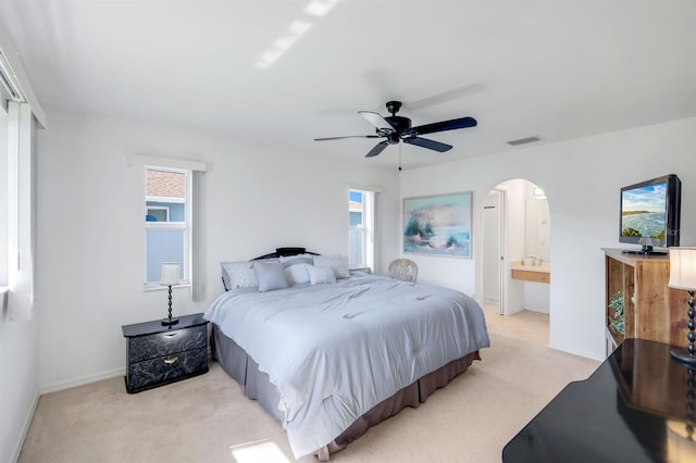 carpeted bedroom featuring connected bathroom and ceiling fan