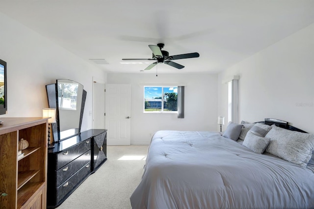 carpeted bedroom featuring multiple windows and ceiling fan