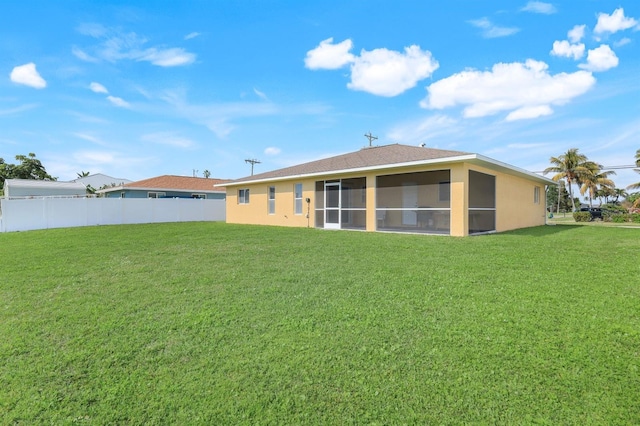 back of house with a lawn and a sunroom