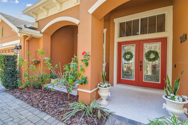 property entrance featuring stucco siding and french doors