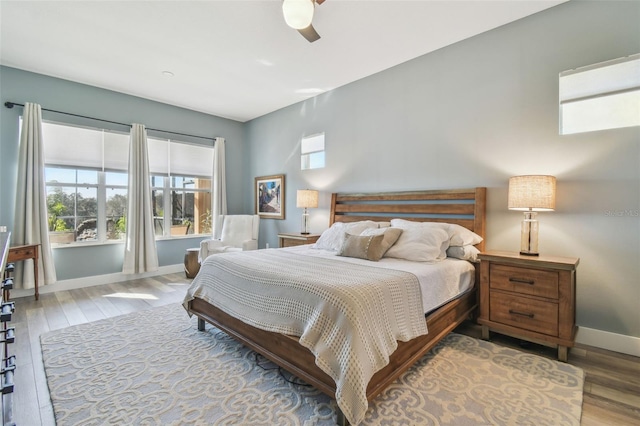 bedroom featuring a ceiling fan, baseboards, and wood finished floors