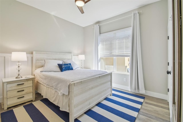 bedroom featuring ceiling fan, light wood finished floors, and baseboards