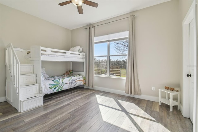 unfurnished bedroom with ceiling fan, baseboards, and wood finished floors