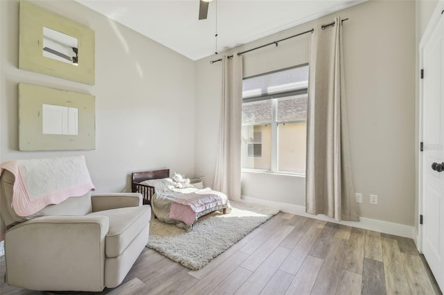 living area with light wood-style floors, ceiling fan, and baseboards