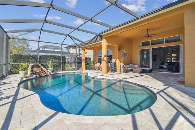 outdoor pool with glass enclosure, ceiling fan, outdoor lounge area, and a patio