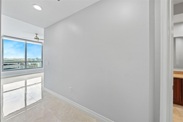 unfurnished room with light tile patterned floors and ceiling fan