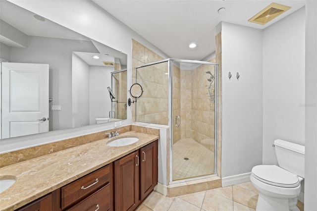 bathroom featuring tile patterned floors, vanity, toilet, and a shower with shower door