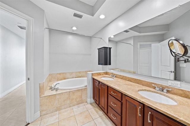 bathroom featuring vanity, tiled tub, and tile patterned floors