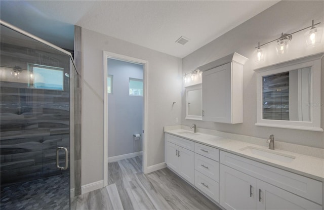 bathroom featuring a shower with door, vanity, and hardwood / wood-style flooring