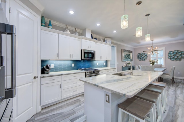 kitchen featuring tasteful backsplash, crown molding, stainless steel appliances, and a sink