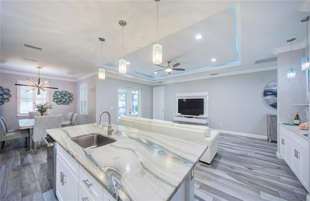 kitchen with open floor plan, ornamental molding, a sink, and a wealth of natural light