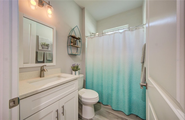 full bath with toilet, curtained shower, wood finished floors, and vanity