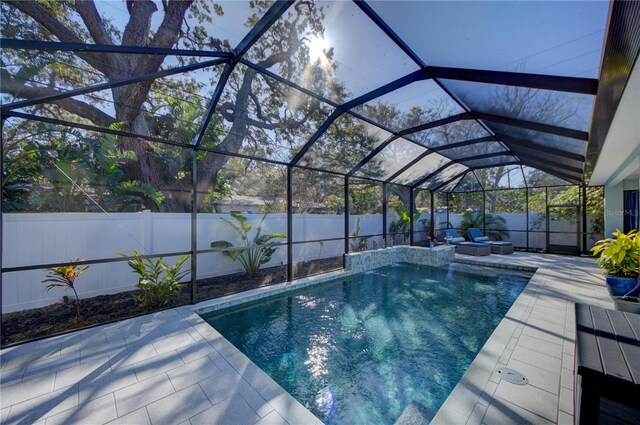 view of swimming pool featuring a patio, a fenced backyard, glass enclosure, and a fenced in pool