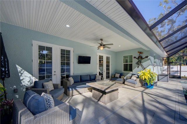 view of patio with glass enclosure, ceiling fan, an outdoor living space, and french doors