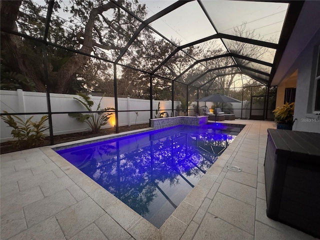 view of swimming pool featuring glass enclosure, a patio area, a fenced backyard, and a fenced in pool